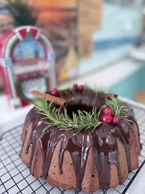 A chocolate bundt cake finished with rosemary and cranberries.