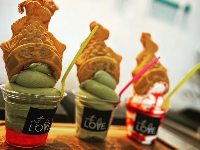 Three cups of soft serve — two matcha, one strawberry — each topped with a whole taiyaki standing upright.