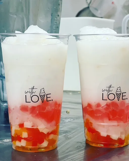 Two cups of layered strawberry milk with jelly cubes, stamped with the with LOVE. logo.