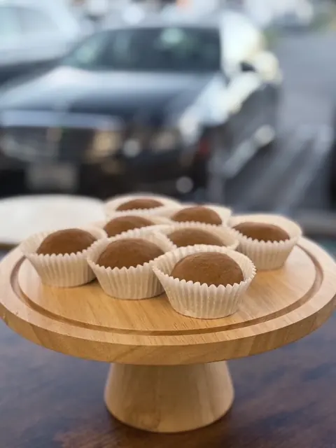 Mini cupcakes arranged on a wooden cake stand.